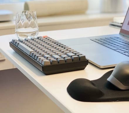 Photo of black phone and black keyboard on a white table