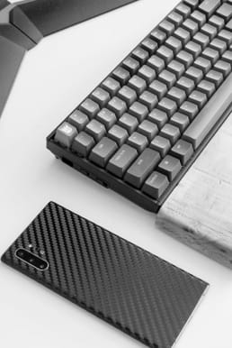 Photo of black phone and black keyboard on a white table